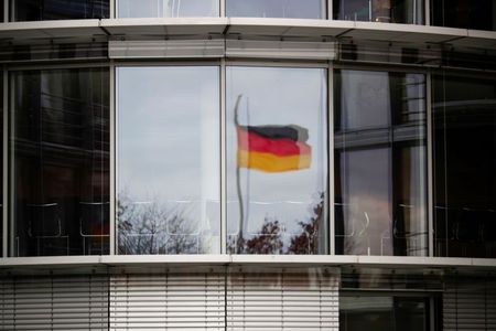 A German flag is reflected in the window of the Paul Loebe building in Berlin, Germany, November 19, 2020. REUTERS/Hannibal Hanschke