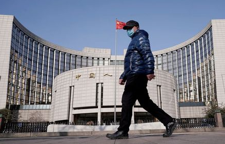 A man wearing a mask walks past the headquarters of the People's Bank of China, the central bank, in Beijing, China, as the country is hit by an outbreak of the new coronavirus, February 3, 2020. REUTERS/Jason Lee