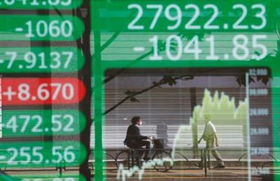 People are reflected on an electric board showing Nikkei index and its graph outside a brokerage at a business district in Tokyo, Japan, June 21, 2021. REUTERS/Kim Kyung-Hoon