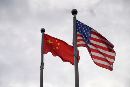 FILE PHOTO: Chinese and U.S. flags flutter outside a company building in Shanghai, China November 16, 2021. REUTERS/Aly Song