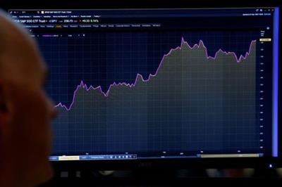 A trader looks at a screen that charts the S&P 500 on the floor of the New York Stock Exchange (NYSE) in New York, U.S., April 27, 2017. REUTERS/Brendan McDermid